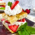 strawberry-shortcake-with-sweet-biscuits-and-whipped-cream-my-home-and-travels- served on a plate with mint featured image